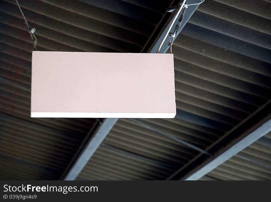 Pink wooden blank signage hanging on the ceiling. Pink wooden blank signage hanging on the ceiling.