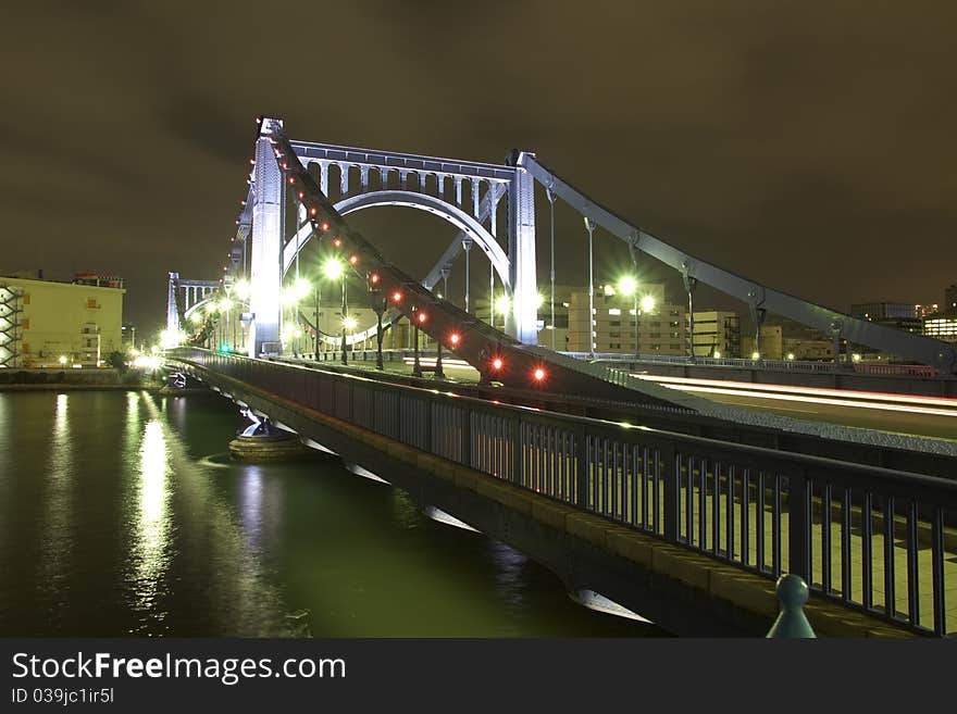 Night time colorful reflection of Kiyosu Bridge illumination in waters of SumidaÂ river of Tokyo , Japan