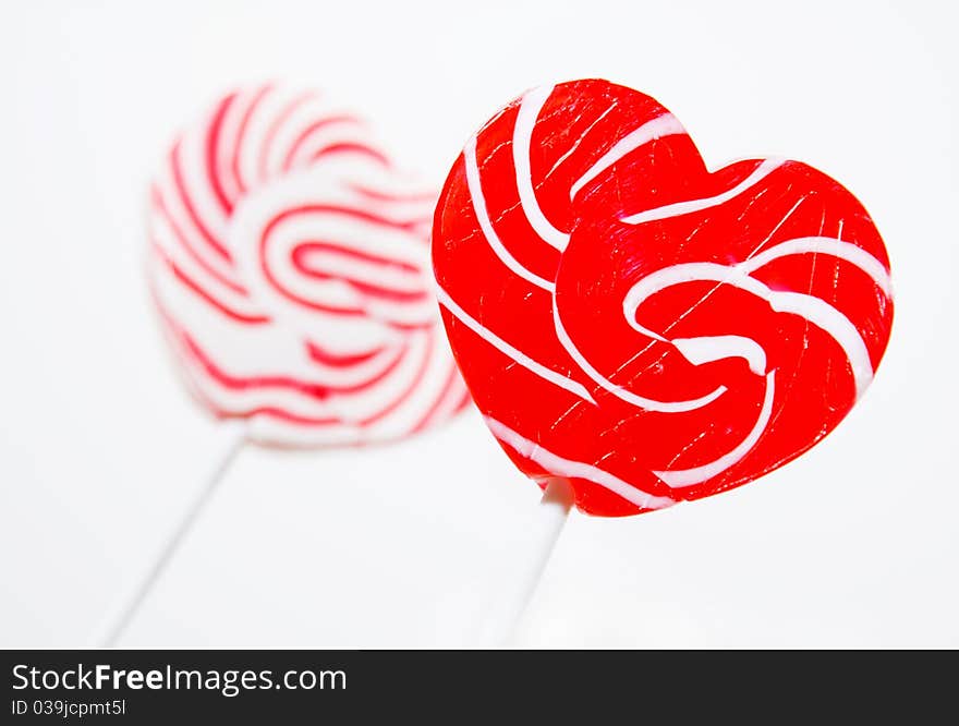 Retro style red , pink heart shape lollipop on white background