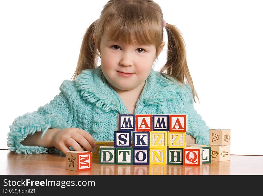 The little girl plays cubes on white