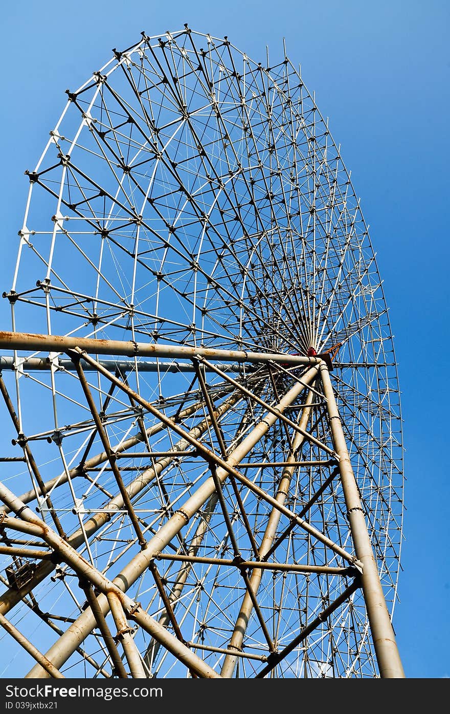 A Ferris wheel is repired in a park