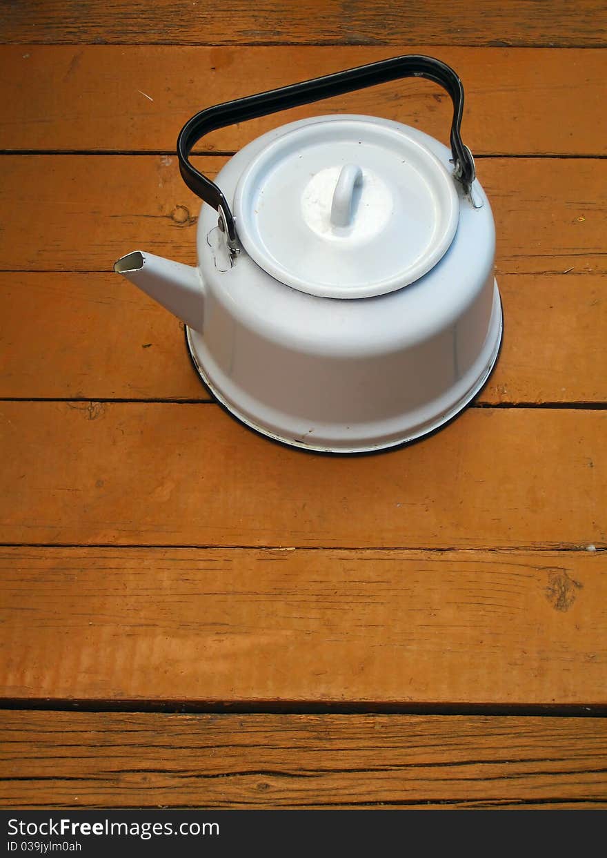 Old classic kettle on the wooden floor. Old classic kettle on the wooden floor