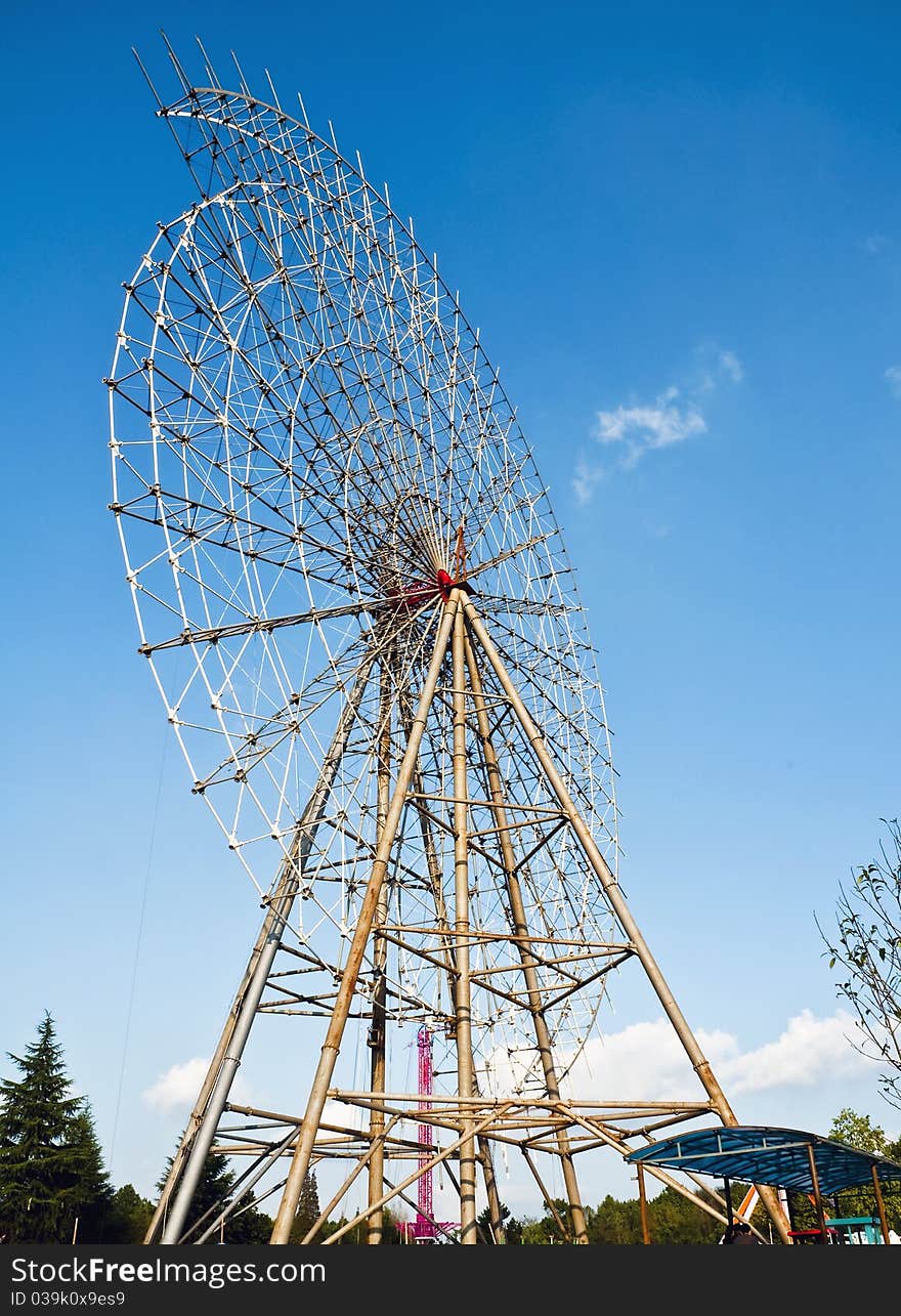 A Ferris wheel is repired in a park