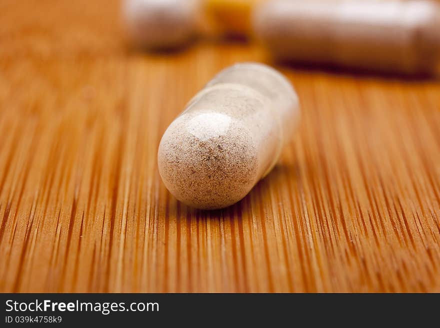 Medical pill against diseases on a wooden table.