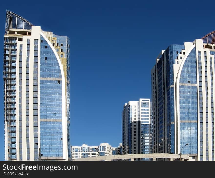 New towerlike buildings against a background of blue sky. New towerlike buildings against a background of blue sky