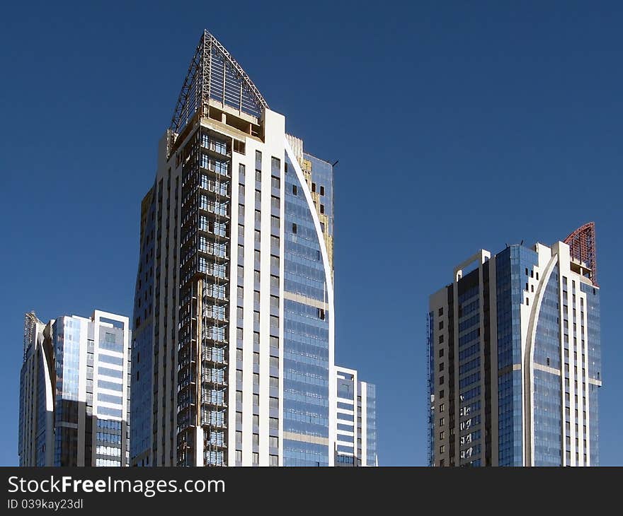 New towerlike buildings against a background of blue sky. New towerlike buildings against a background of blue sky