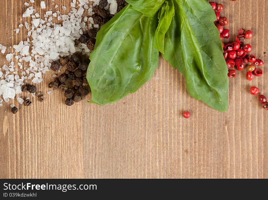 Border os fresh herbs, salt and pepper's mix on wooden background