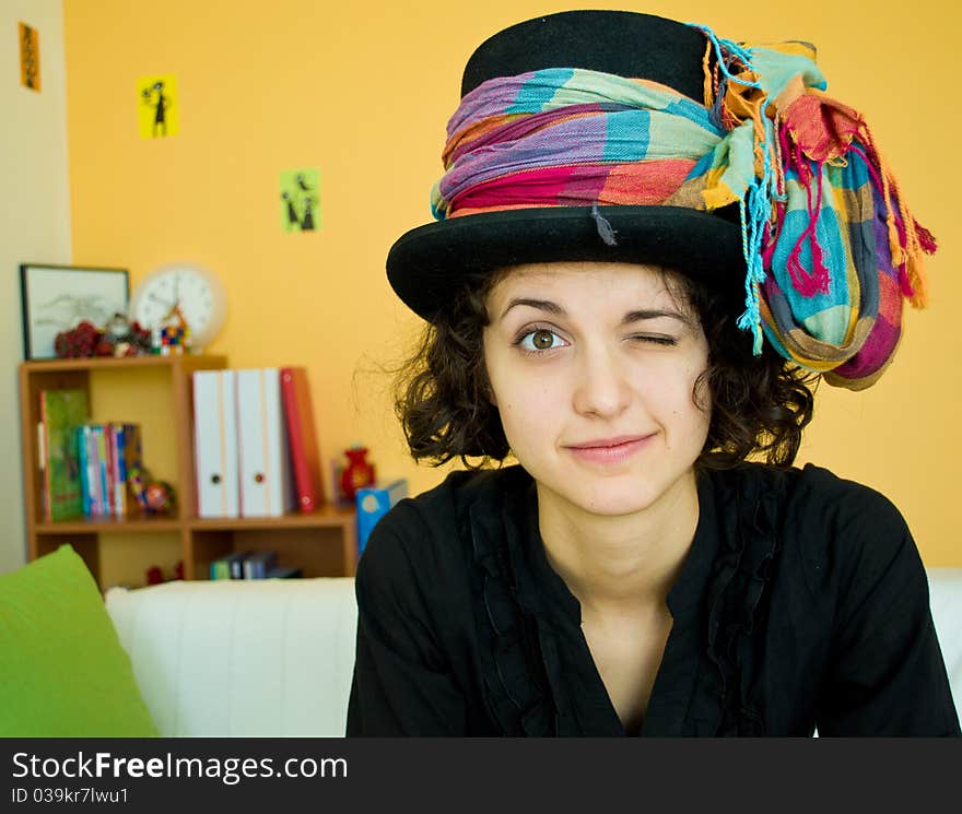 Portrait of a young woman with a black magician hat and a colorful scarf. Portrait of a young woman with a black magician hat and a colorful scarf