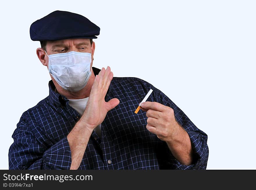 Man with a mask on, pushing away a cigarette which is in his other hand, resisting the temptation of smoking. Man with a mask on, pushing away a cigarette which is in his other hand, resisting the temptation of smoking.