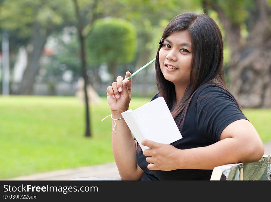 Women sitting in the park and hold a white card. Women sitting in the park and hold a white card.