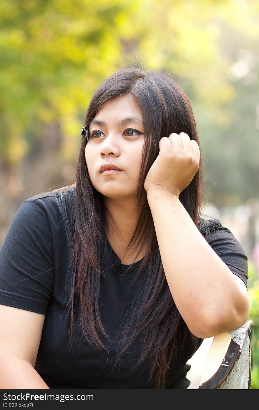 Woman sitting in a park looking vacant. Woman sitting in a park looking vacant