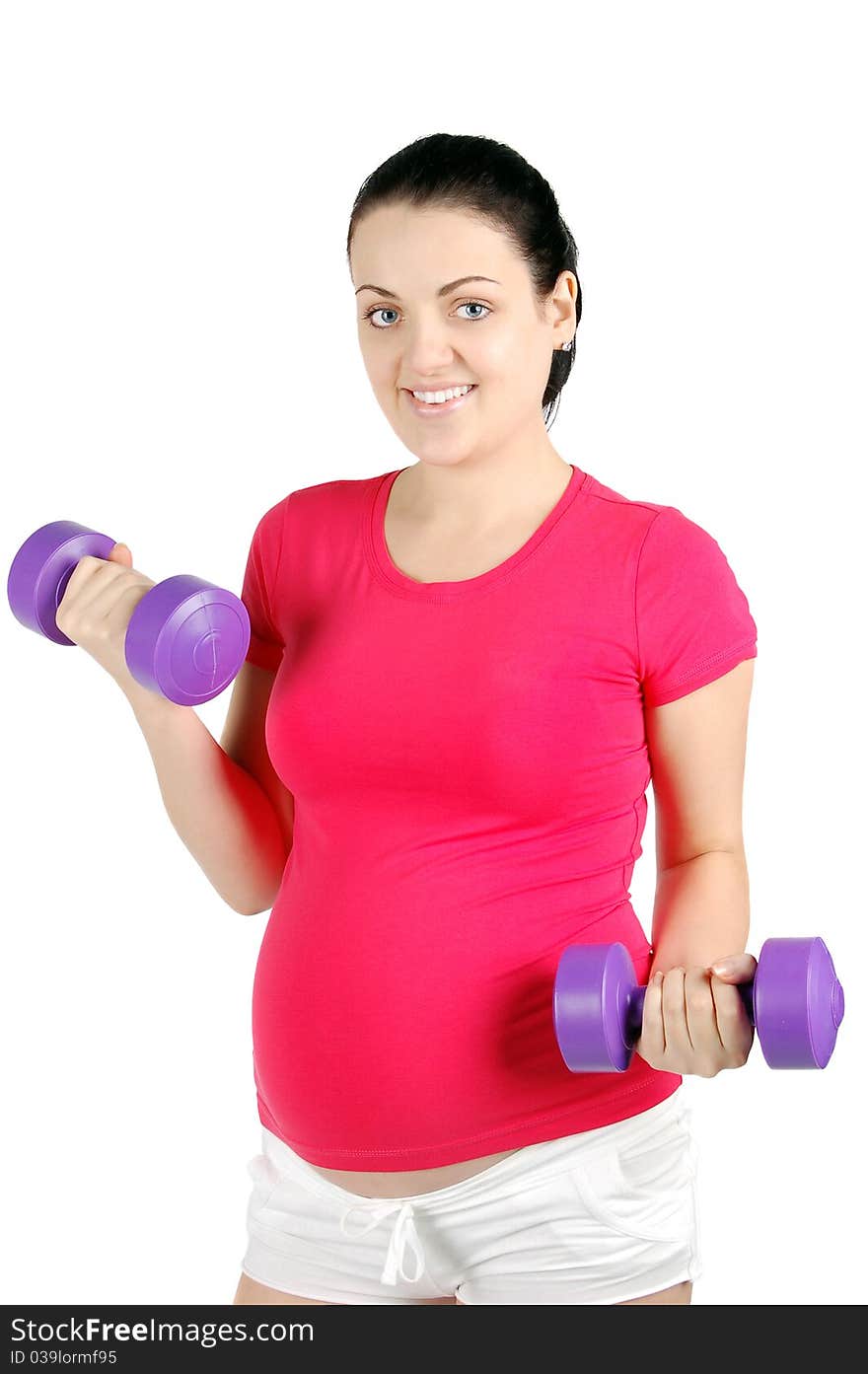 Young pregnant woman making exercise with dumb bells
