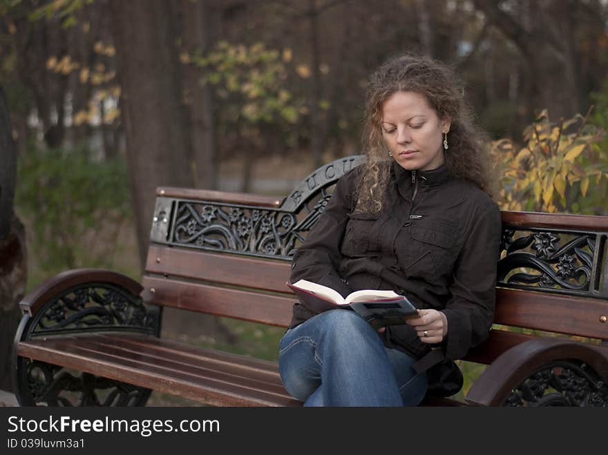 Curly girl reading in a park