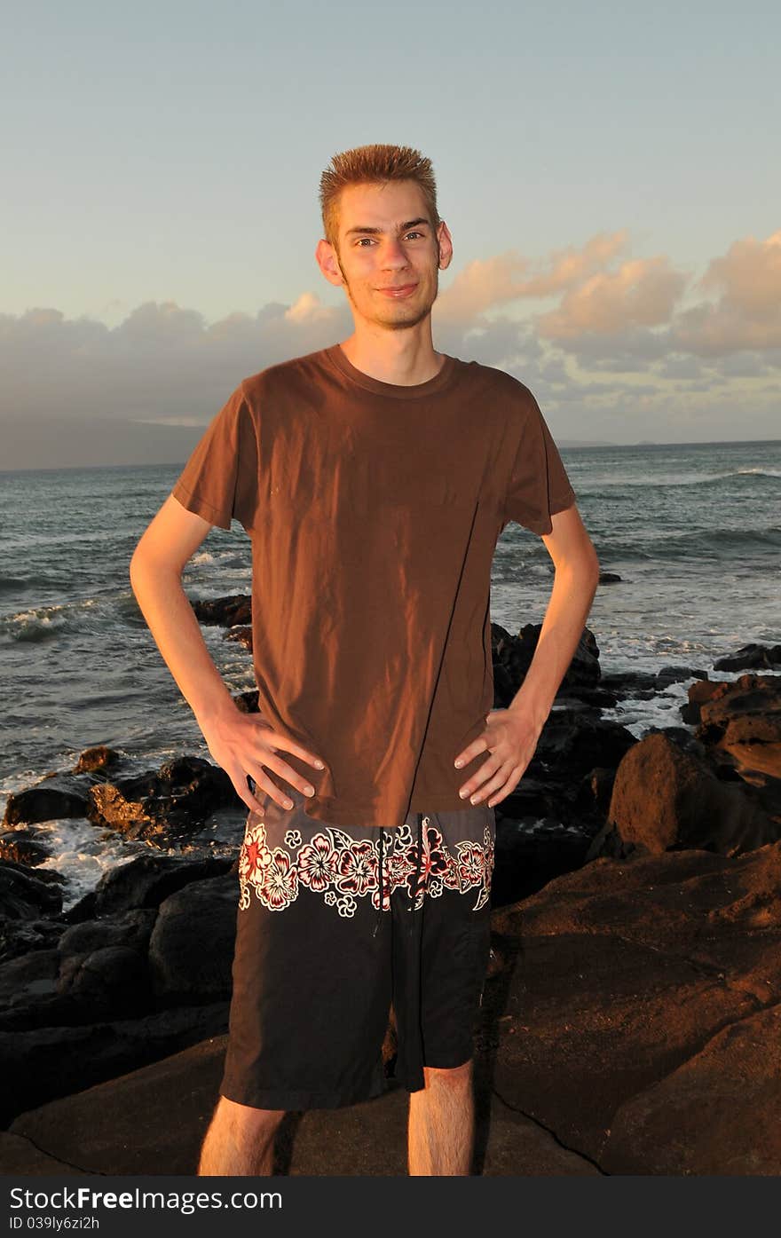 Single young 19 year old teenage adult standing on the beach smiling. Single young 19 year old teenage adult standing on the beach smiling