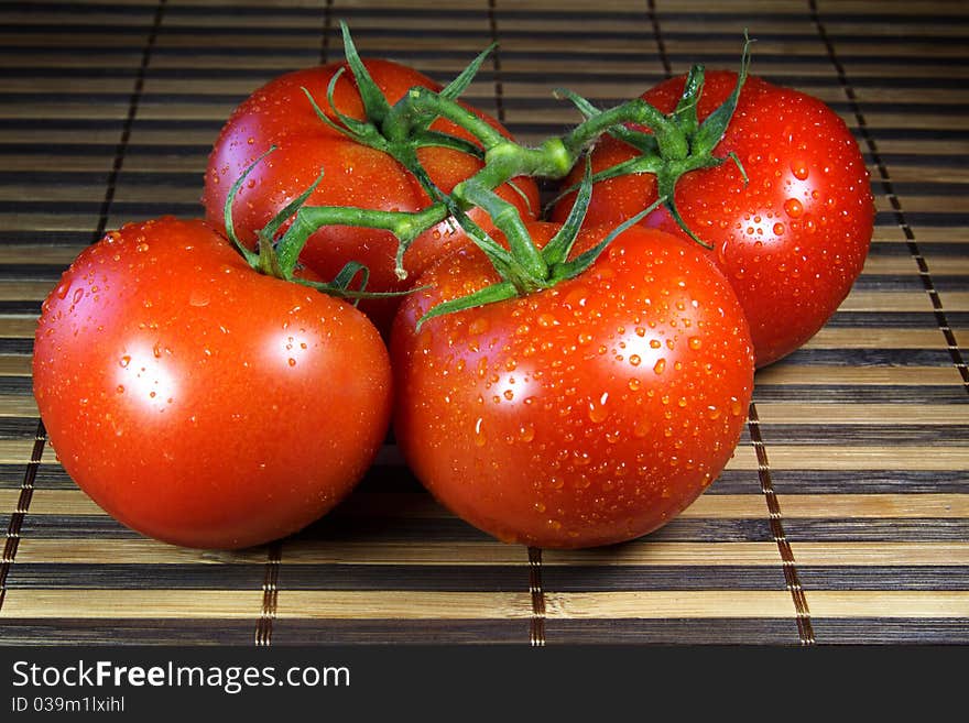 Deliciously fresh vine ripened tomatoes on bamboo matting.