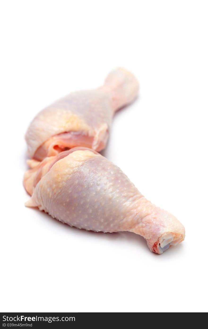 Close up of two raw chicken drumsticks isolated on white background.