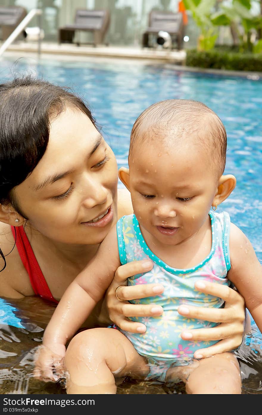 Asian ethnic mom and baby girl at swimming pool. Asian ethnic mom and baby girl at swimming pool