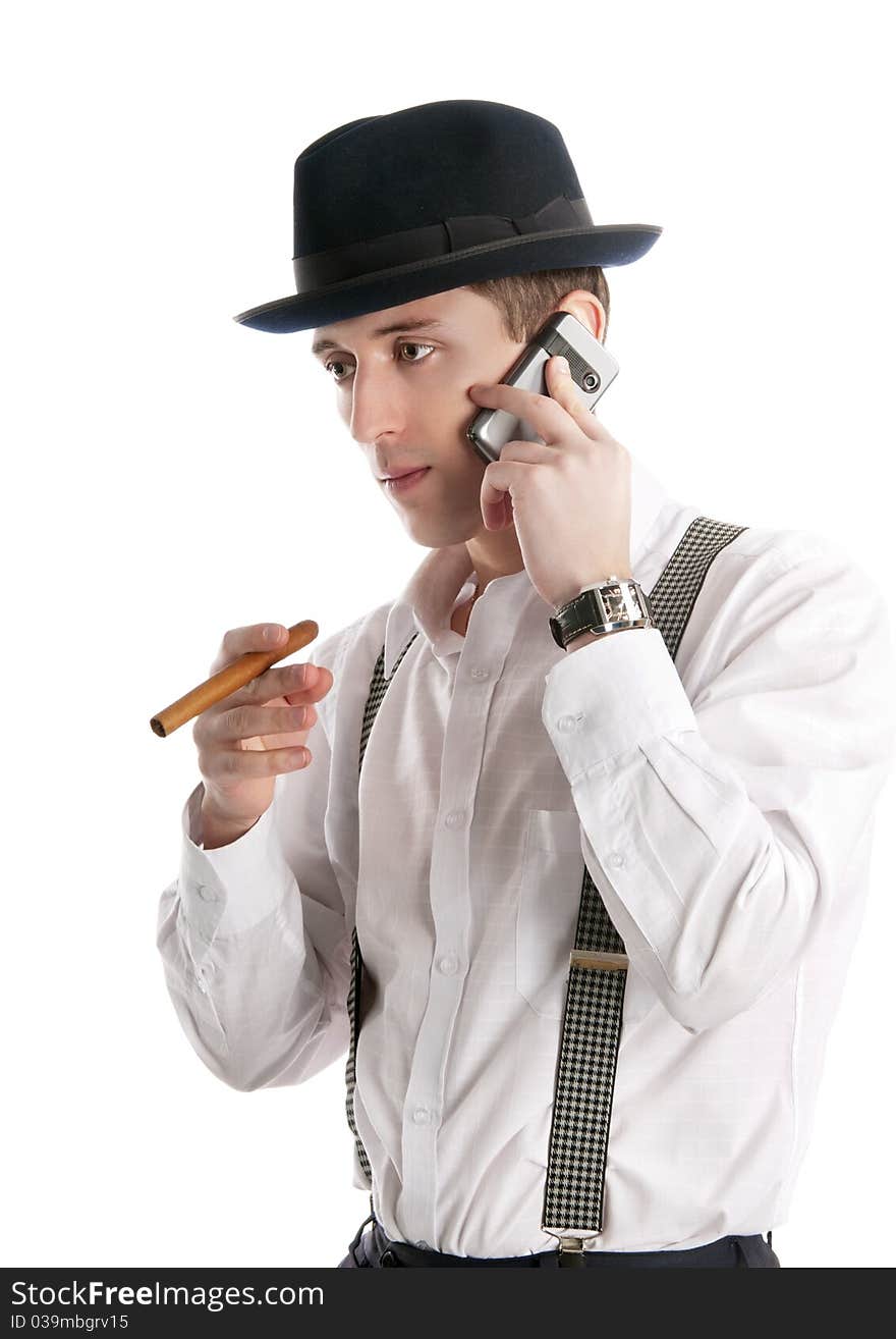 Young man talks by a mobile phone and holds cigar.