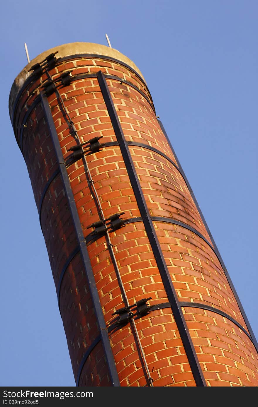 An old red brick chimney smoke stack against a blue sky at Plattsburgh Community College in upstate New York State.