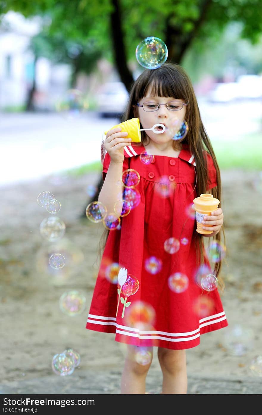 Beauty little girl with long dark hair in red old style dress with soap bubbles. Beauty little girl with long dark hair in red old style dress with soap bubbles