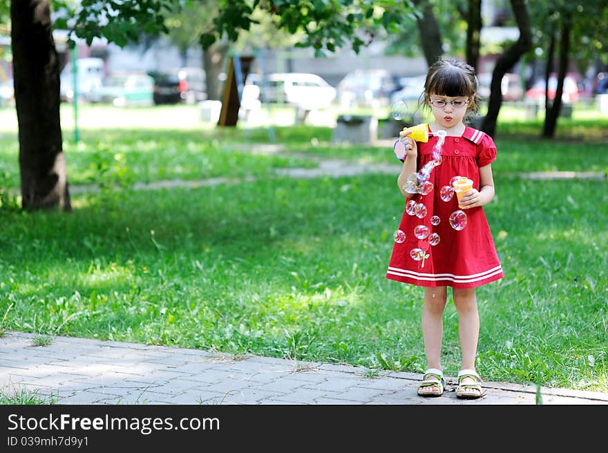 Beauty little girl with long dark hair in red old style dress with soap bubbles. Beauty little girl with long dark hair in red old style dress with soap bubbles