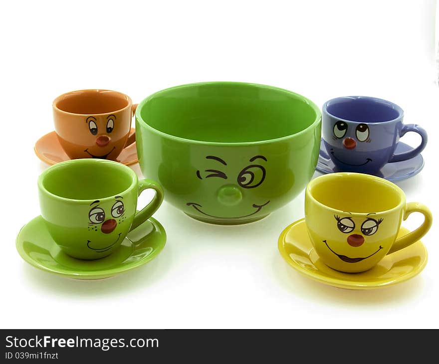 Four kid's cups beside a green bowl on the White Background