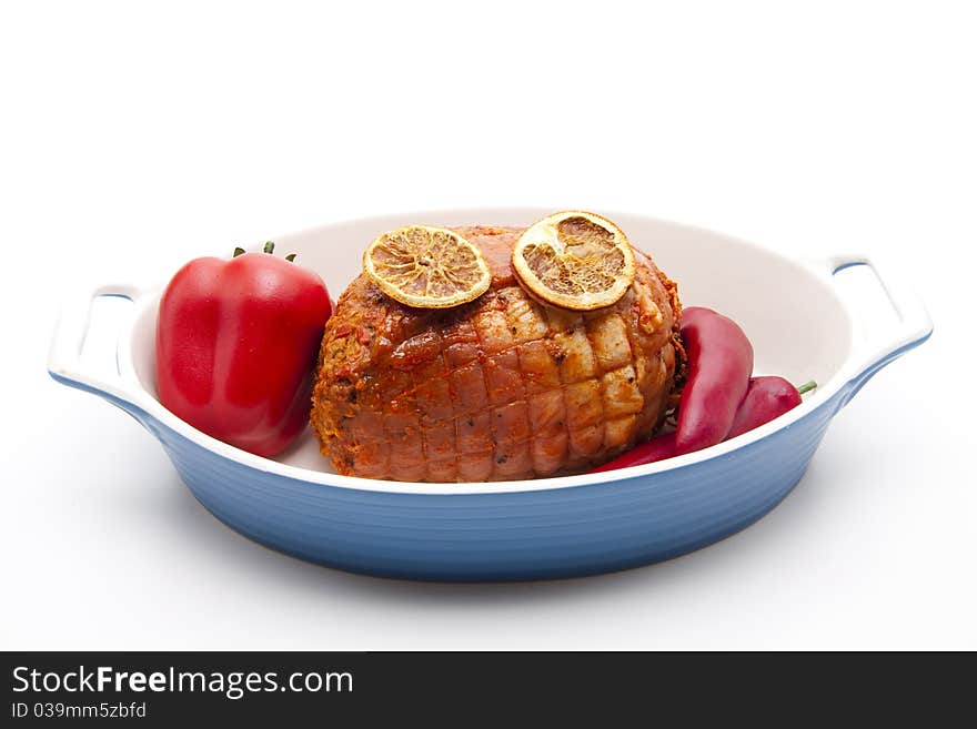 Rotation roast seasoned with chilli, paprika in the casserole dish and lemon