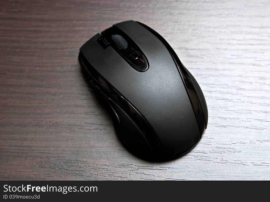 Black wireless pc mouse on table. Studio shot. Black wireless pc mouse on table. Studio shot