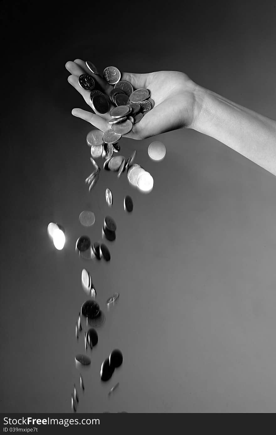 Hand dropping coins in black and white. Hand dropping coins in black and white