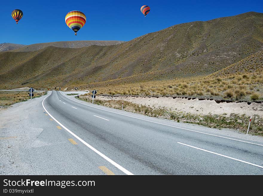 Colorful balloon flying above road to Omarama