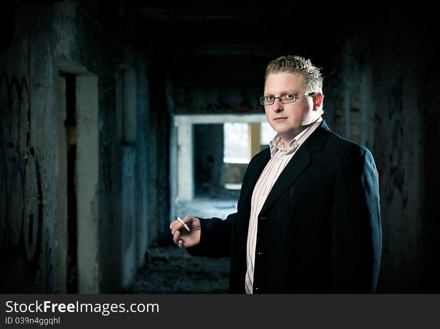 Stilish man with cigarette on building ruins background