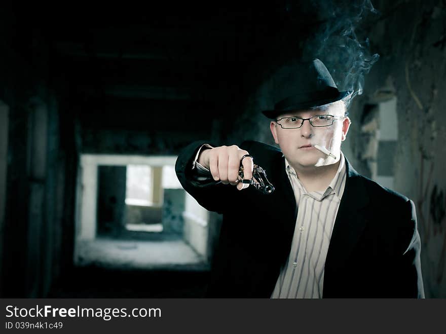 Gangster with pistol in abandoned house background