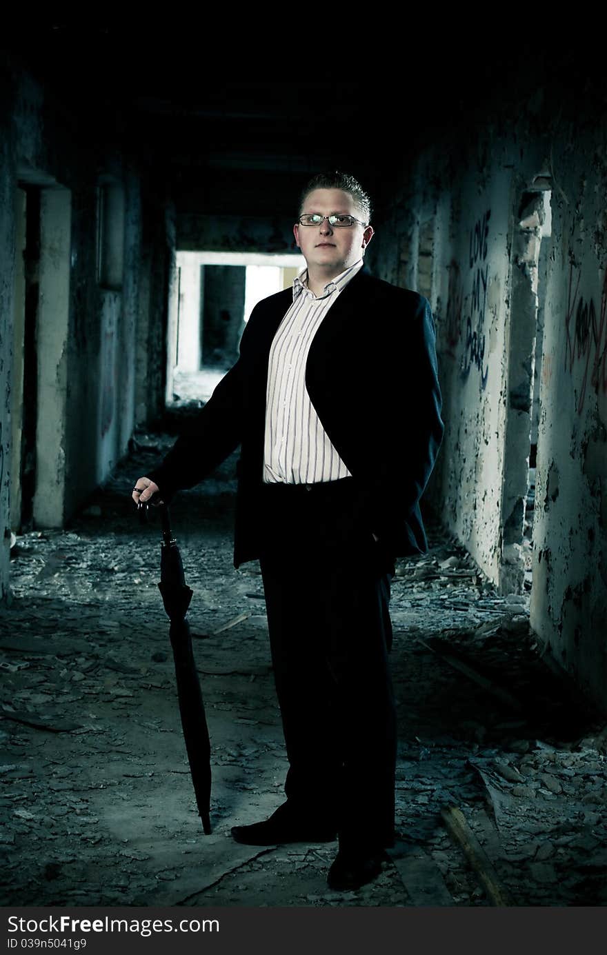 Man in suit with cane on abandoned building background. Man in suit with cane on abandoned building background