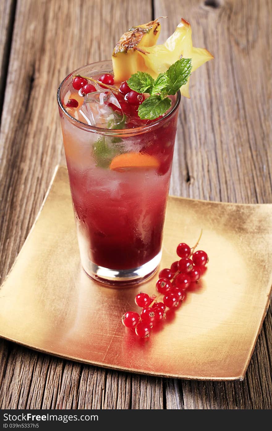 Glass of iced drink garnished with fresh fruit