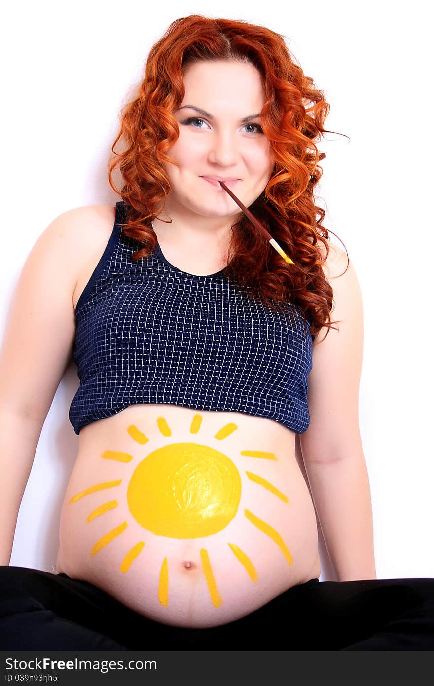 Conceptual image of happy pregnant female with painted pictures on her belly