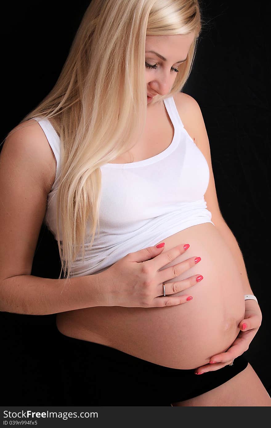 Young pregnant blond woman holding her belly