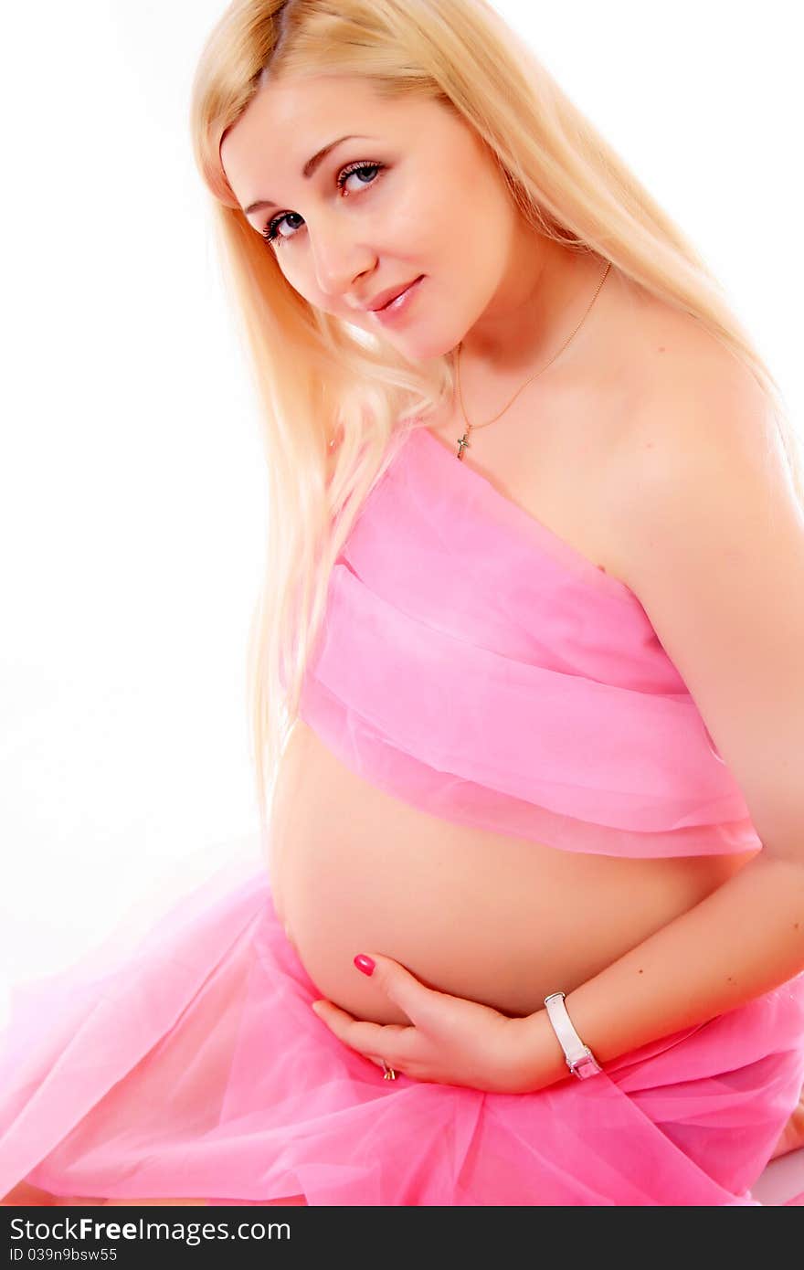 Young pregnant blond woman holding her belly