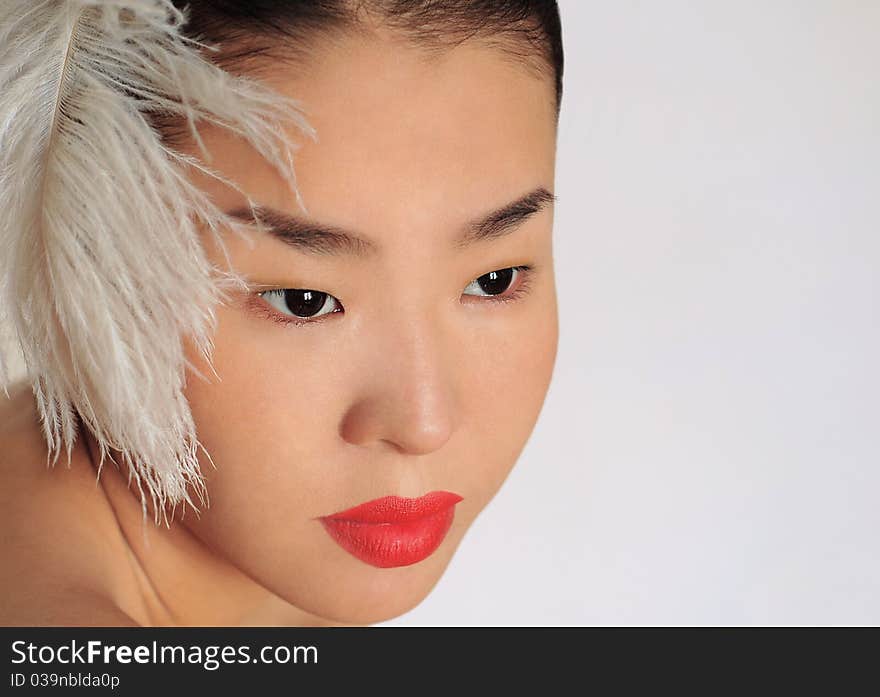 A beautiful young Asian girl with a feather. A beautiful young Asian girl with a feather