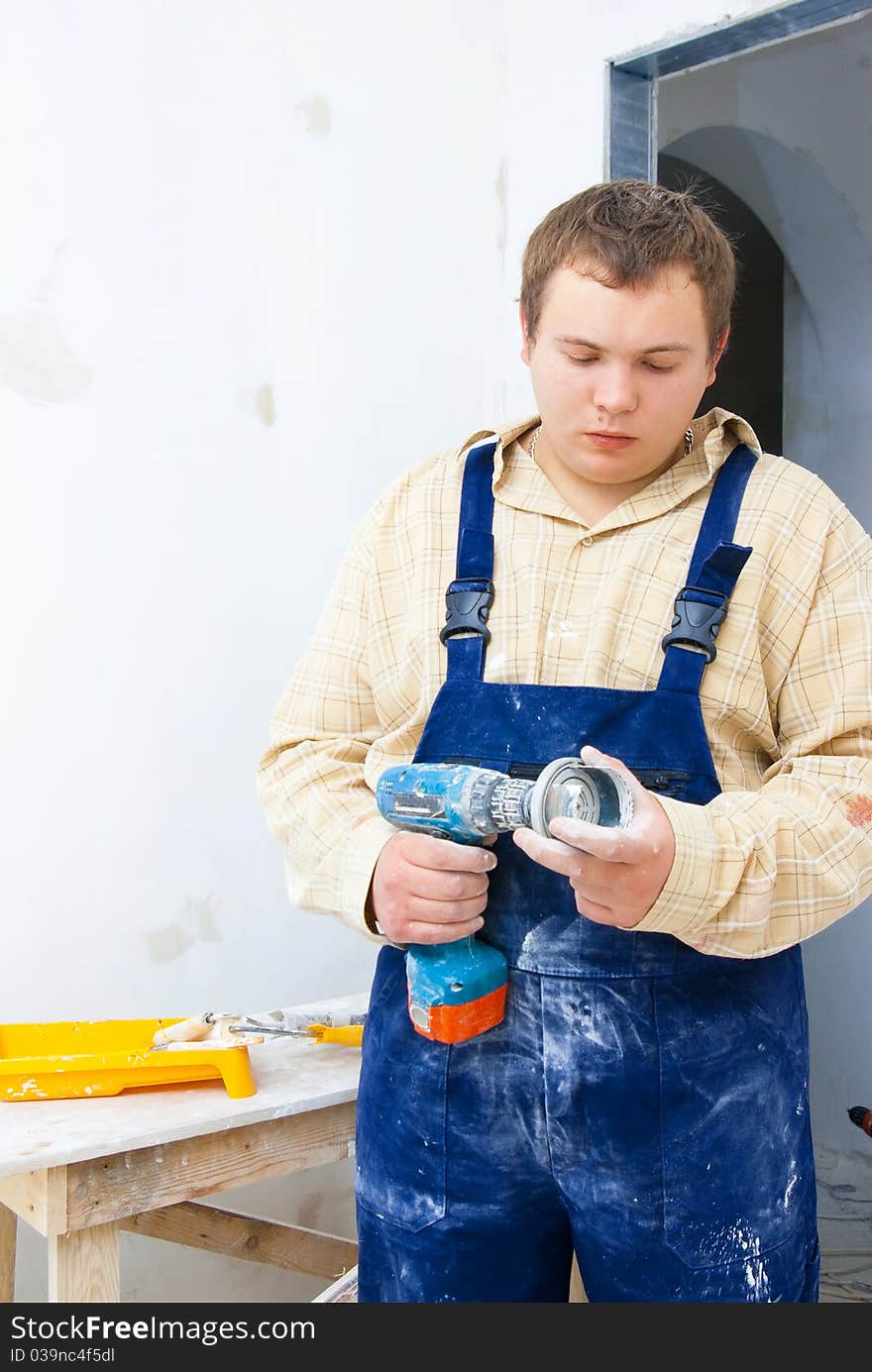 Young worker hold drill in hand. Home renovation theme