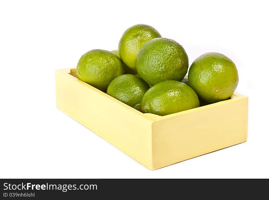 Pile of fresh limes in wooden box