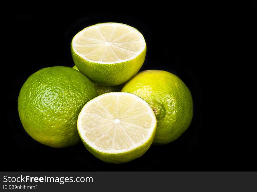 Pile of fresh limes across black