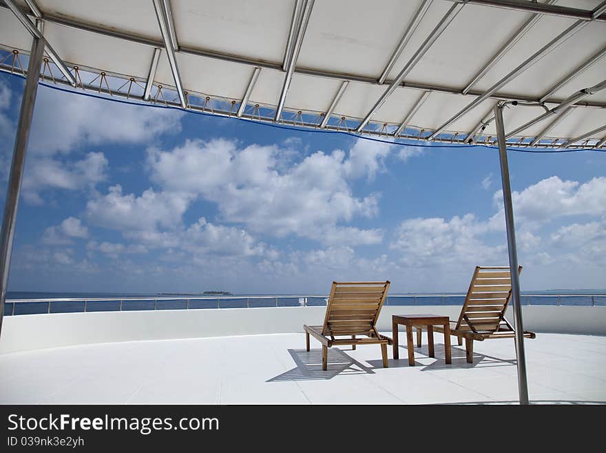 Deck chair on cruising ship are overlooking blue sky and blue indian ocean.