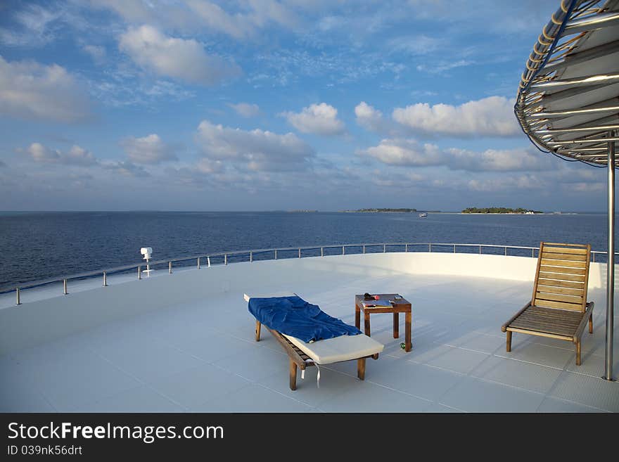 Deck chair on cruising ship are overlooking blue sky and blue indian ocean.