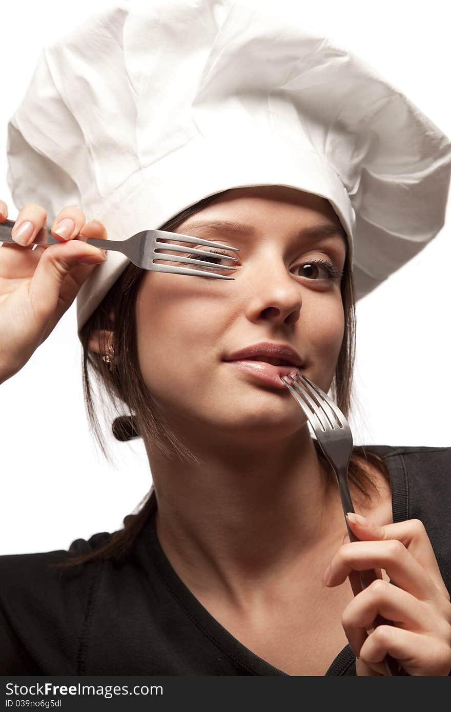 Portrait of a pretty young smiling  uniformed female Chef looking through forks