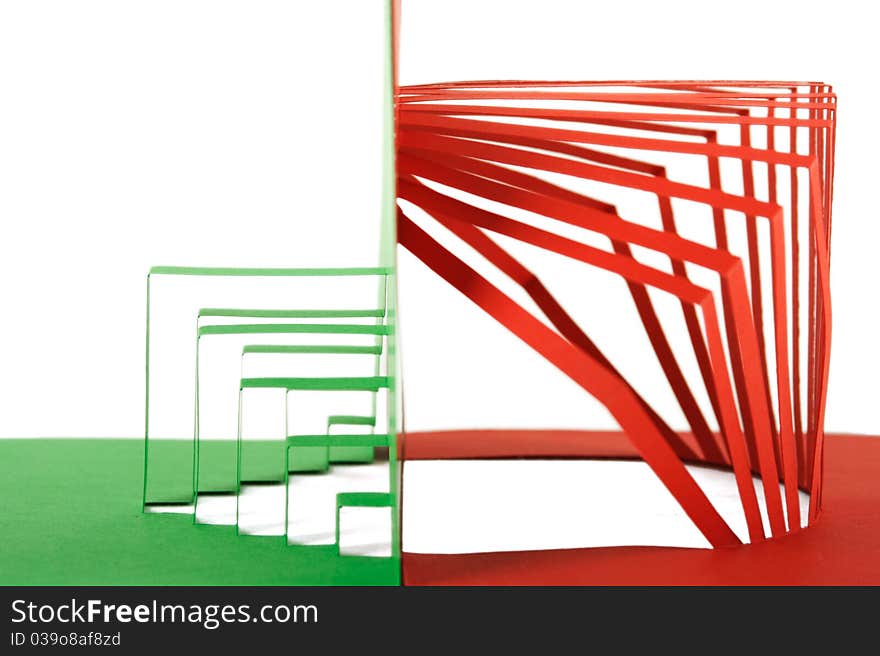 Abstract green and red paper composition with cutout stripes and folds, side view, isolated