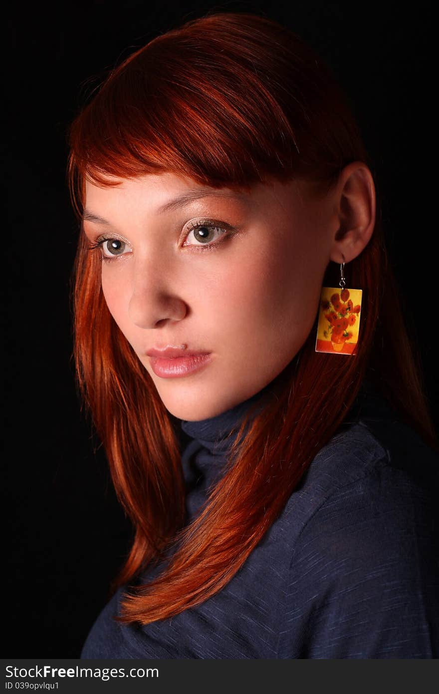 The red-haired girl looking through a shoulder on a black background. The red-haired girl looking through a shoulder on a black background