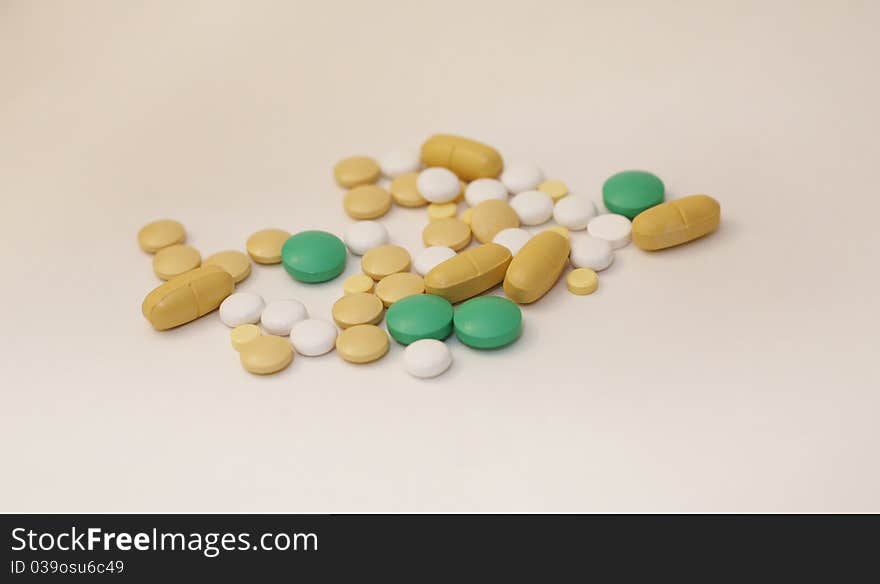 Many multi-colored tablets lie on a white background (small depth of sharpness)