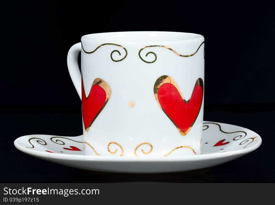 White cup with hearts isolated on black background. White cup with hearts isolated on black background.