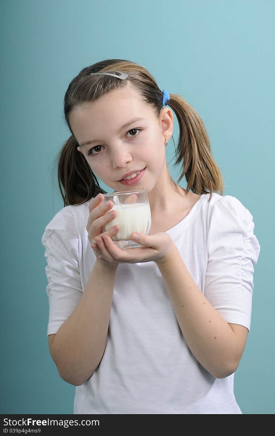 White schoolgirl educating people for healthy life and presenting glass with dairy product. White schoolgirl educating people for healthy life and presenting glass with dairy product