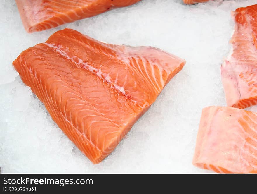 The big pieces of red fish on ice in the fish market. The big pieces of red fish on ice in the fish market